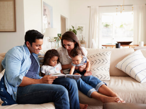 Young family at home in Texas City with their children during reading time.